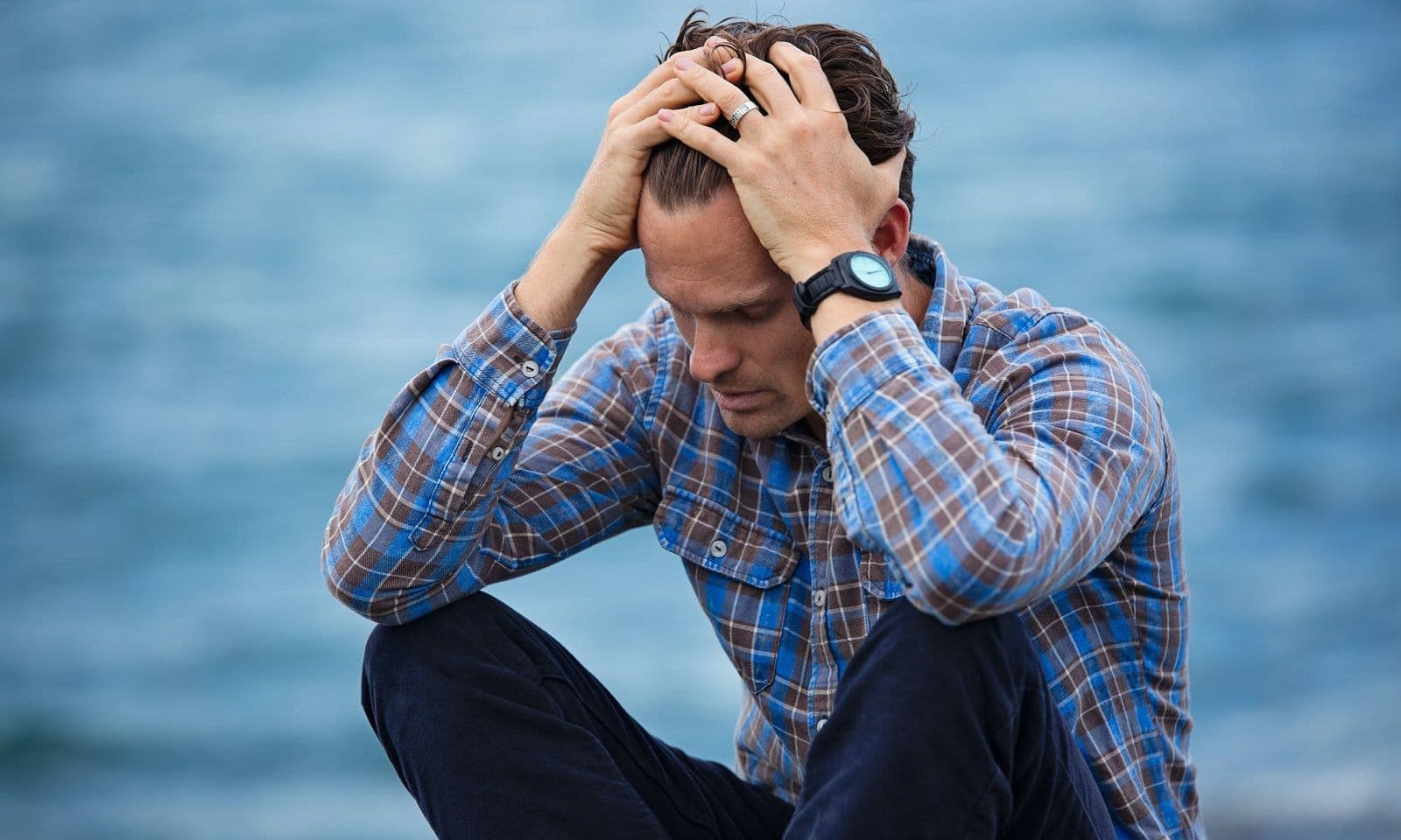Devastated man sitting with his head in his hands